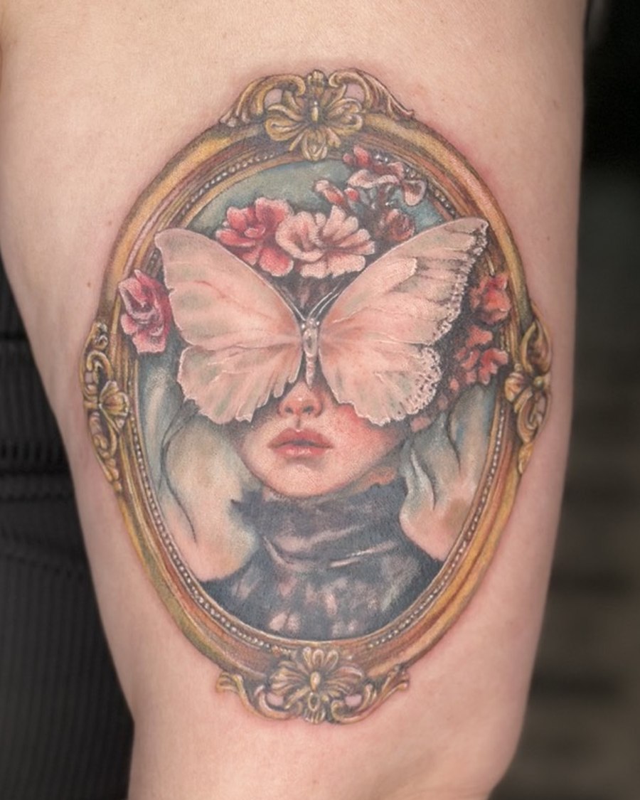 Framed portrait tattoo with a moth covering the eyes