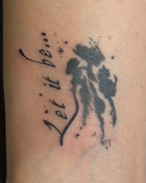 'Let it be' script tattoo with bird silhouette on wrist